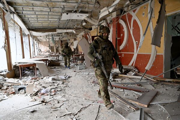 “瓦格纳”私人军事集团的战士们在阿尔乔莫夫斯克市中心检查在战斗中受损的建筑物。 - 俄罗斯卫星通讯社