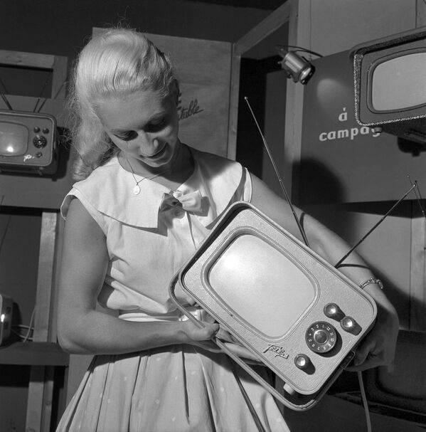 1959年，巴黎，一名女子在节目中展示晶体管收音机。世界上第一个晶体管收音机是由贝尔实验室的技术人员、美国科学家威廉·肖克利、约翰·巴丁和沃尔特·布拉顿于1947年发明，并于1947年12月24日成功测试的。1956年，他们被授予诺贝尔物理学奖。(法新社摄) - 俄罗斯卫星通讯社