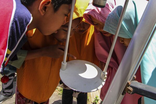 印尼日惹，孩子们观察望远镜底座反射出的日食。 - 俄罗斯卫星通讯社