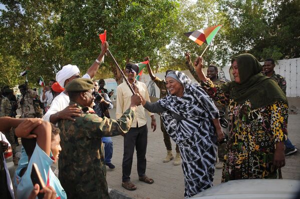 4月20日，人们在苏丹港欢迎忠于阿卜杜勒·法塔赫·布尔汉领导的正规军高级将领奥斯曼·穆罕默德（左）。 - 俄罗斯卫星通讯社