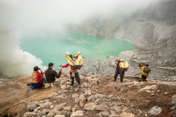 2010年4月24日，工人在印度尼西亚宜珍火山口内运送硫磺。每人背着约60公斤的重物到达裂口顶部，然后向下行进3 公里。 - 俄罗斯卫星通讯社