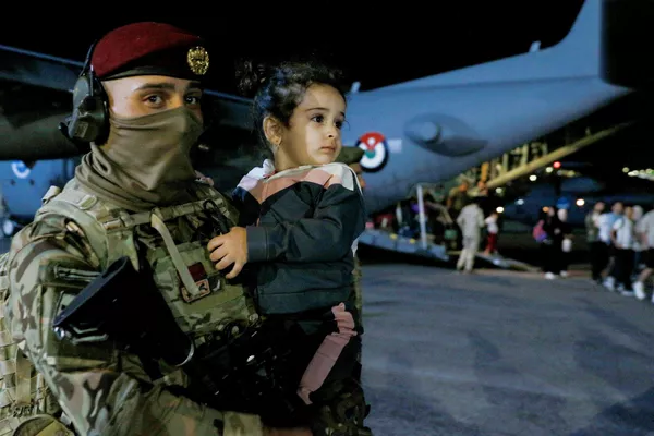 外国撤侨专机降落在约旦安曼的一个军用机场。图为士兵手抱一名从苏丹撤离的儿童。 - 俄罗斯卫星通讯社