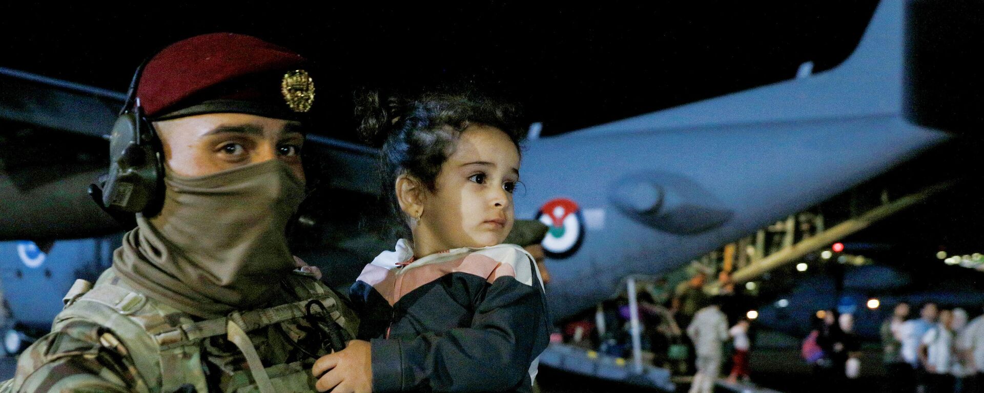 外國撤僑專機降落在約旦安曼的一個軍用機場。圖為圖為士兵手抱一名從蘇丹撤離的兒童。 - 俄羅斯衛星通訊社, 1920, 24.04.2023
