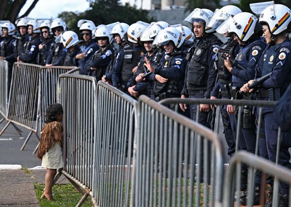 2023年4月24日，巴西利亞的國會大廈外，土著居民舉行抗議活動，一名土著男孩與站崗的警察交談。 - 俄羅斯衛星通訊社