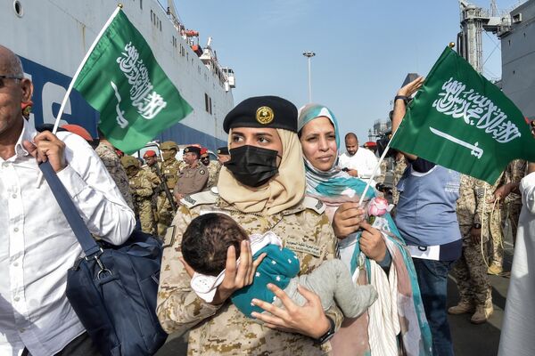 2023年4月26日，一名沙特水兵抱着一名儿童。沙特外交部表示，一艘载有来自50多个国家1687名平民的船只于4月26日从苏丹抵达沙特阿拉伯，这是该国迄今为止最大的一次撤离行动。 - 俄罗斯卫星通讯社