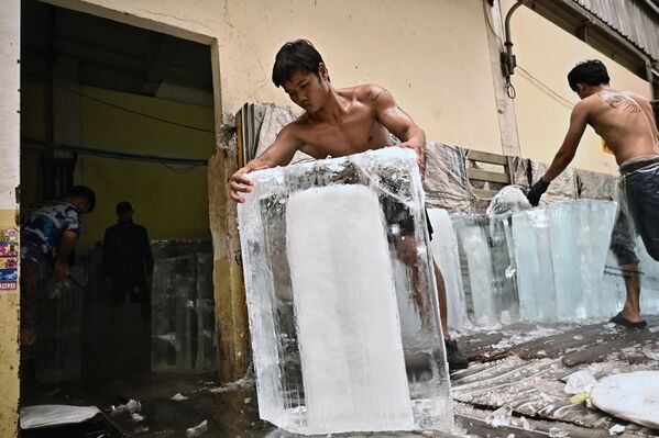 2023年4月25日，曼谷，工人在热浪中将冰块移入市场的一个存储间。 - 俄罗斯卫星通讯社