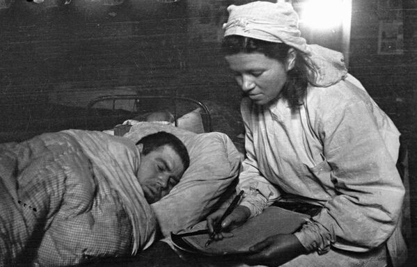 第一波羅的海戰線上，醫療隊護士在一名傷兵的口述下給親人寫信。  - 俄羅斯衛星通訊社