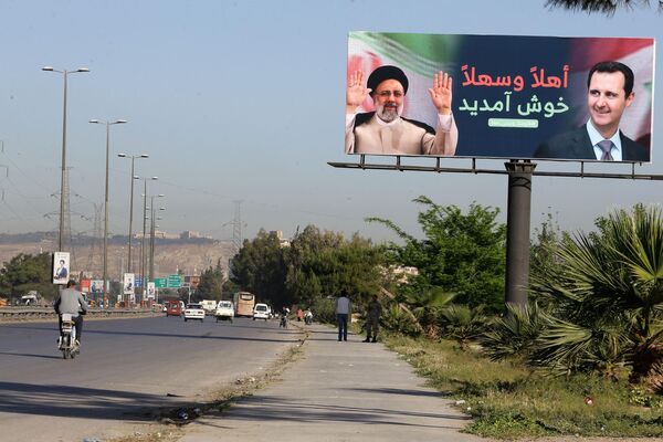 2023年5月3日，伊朗总统易卜拉欣·莱希(左)和叙利亚总统巴沙尔·阿萨德的照片广告牌矗立在通往大马士革国际机场的道路上。莱希于今天前往大马士革，这是叙利亚内战爆发以来伊朗总统首次访问大马士革，目前该地区与这两个盟国的接触正在扩大。(LOUAI BESHARA /法新社摄) - 俄罗斯卫星通讯社