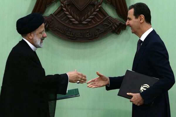 2023年5月3日，叙利亚总统巴沙尔·阿萨德(右)和伊朗总统易卜拉欣·莱希在大马士革签署“长期战略合作”谅解备忘录后握手。来访的伊朗总统称赞阿萨德克服制裁，在长达12年的内战中取得了“胜利”。德黑兰一直是叙利亚内战的主要盟友。(LOUAI BESHARA /法新社摄) - 俄罗斯卫星通讯社