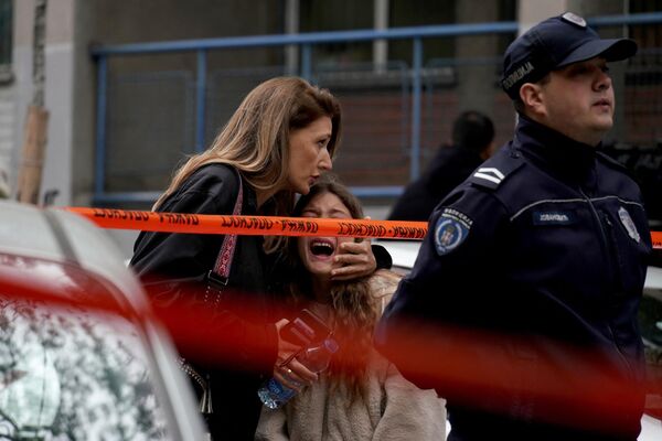 2023年5月3日，首都贝尔格莱德一所学校发生枪击事件，一名家长在一旁护送她的孩子。塞尔维亚内政部表示，塞尔维亚警方于2023年5月3日在首都贝尔格莱德的一所小学逮捕了一名学生。枪击事件发生在当地时间上午8点40分(格林尼治标准时间6点40分)，地点是贝尔格莱德市中心弗拉卡尔区的一所小学。(法新社/Oliver Bunic) - 俄罗斯卫星通讯社
