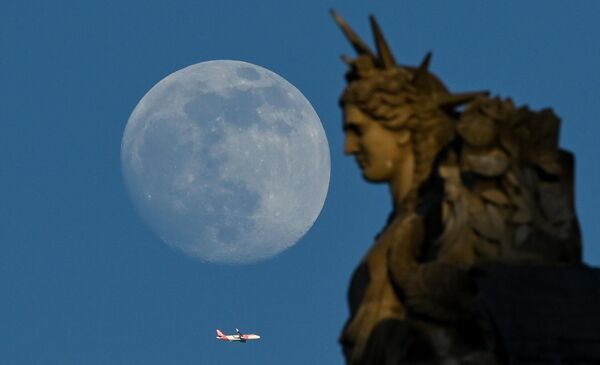2023年5月3日，巴黎，一架飛機從盧浮宮的雕像旁飛過。(Stefano RELLANDINI/法新社) - 俄羅斯衛星通訊社