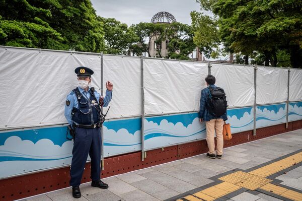 廣島和平紀念公園圍欄前的一位路人和警察。 - 俄羅斯衛星通訊社