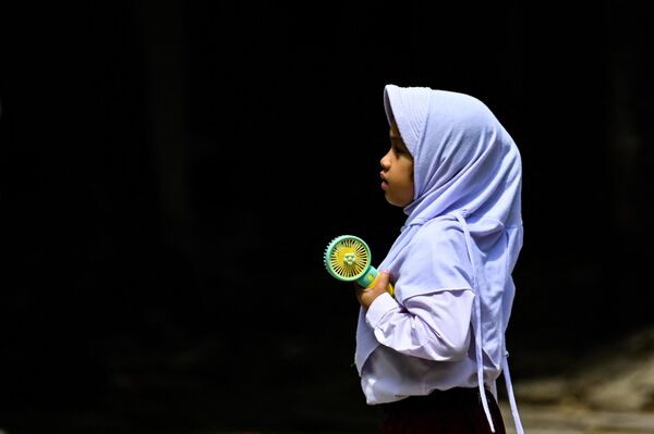 印度尼西亚班达亚齐的一名小学生使用便携式风扇为自己降温。 - 俄罗斯卫星通讯社