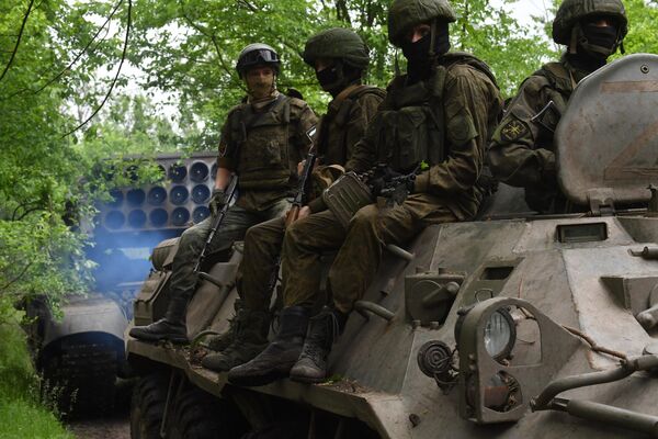 特别军事行动区域里，战士们乘坐装甲车护送TOS-1A“日炙”重型喷火系统。 - 俄罗斯卫星通讯社