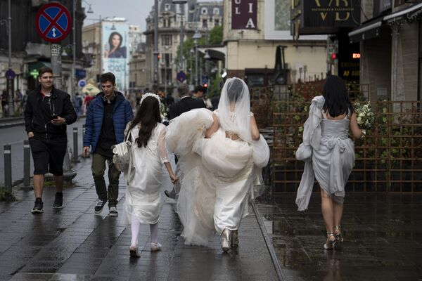 一位新娘在雨後的羅馬尼亞布加勒斯特街道漫步。 - 俄羅斯衛星通訊社