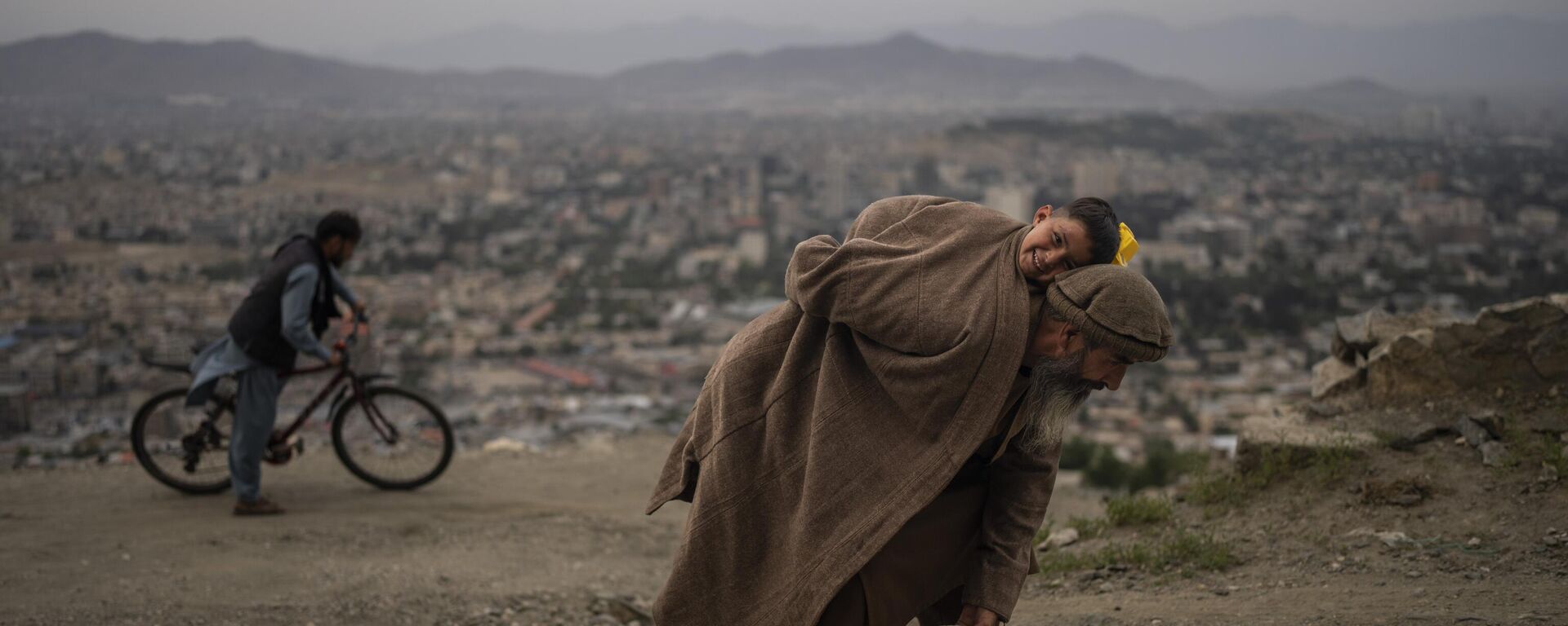 Абдул Кадер Газизада убирает камни с дороги, неся на руках своего 2-летнего сына, Афганистан - 俄羅斯衛星通訊社, 1920, 23.03.2024