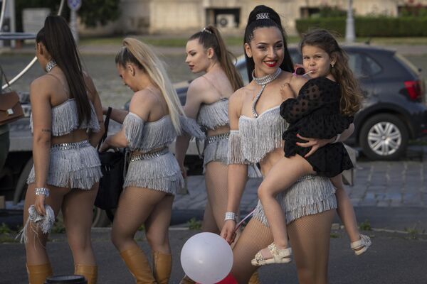 6月3日,罗马尼亚布加勒斯特市中心街头表演后,大都会马戏团的一位表演者抱着一个小女孩。 6月3日,罗马尼亚布加勒斯特市中心街头表演后,大都会马戏团的一位表演者抱着一个小女孩。 - 俄罗斯卫星通讯社