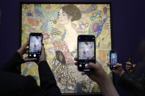 英国伦敦，人们拍摄正在苏富比拍卖会上展出的古斯塔夫·克里姆特的画作《持扇的女子》 - 俄罗斯卫星通讯社