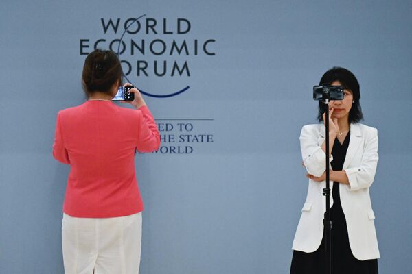 2023年6月28日，在天津举行的世界经济论坛2023年新领军者年会期间，一名志愿者（左）和一名记者（右）在梅江会展中心正使用各自的手机。 - 俄罗斯卫星通讯社