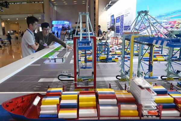 2023年6月28日，在天津举行的世界经济论坛2023年新领军者年会期间，人们在梅江会展中心观看“智慧零碳”集装箱码头模型。 - 俄罗斯卫星通讯社
