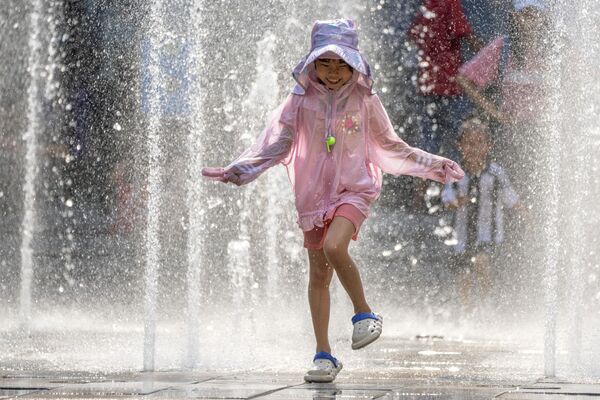 中國北京，大熱天里，一個女孩在商場附近的噴泉里戲水。 - 俄羅斯衛星通訊社