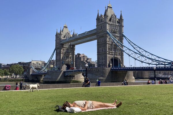 一名女子在倫敦塔橋附近的草地上曬日光浴。 - 俄羅斯衛星通訊社