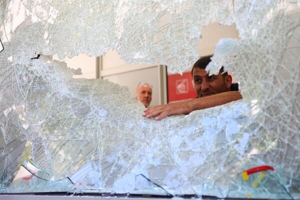 7月1日，法国马赛市中心一家法国储蓄银行的清洁和安保人员正在检查受损的窗户。此前，法国因警察射杀少年事件而连续第4晚发生骚乱。 - 俄罗斯卫星通讯社