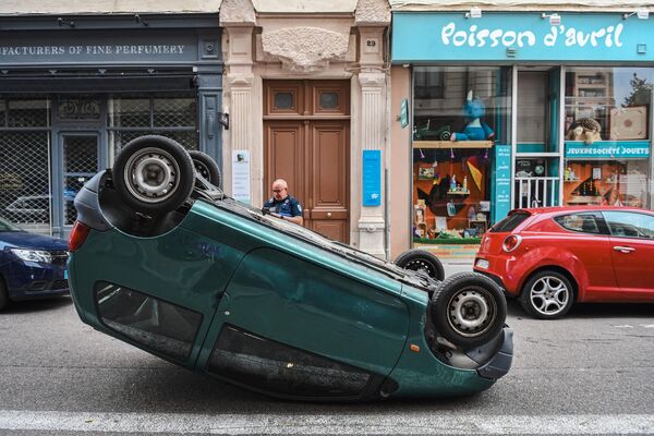 7月1日，法国里昂市，一名警察站在一辆反倒在街上的汽车旁。 - 俄罗斯卫星通讯社
