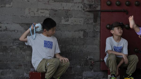 2023年7月7日，星期五，悶熱的北京，一個男孩在故宮附近用電風扇給自己降溫。 - 俄羅斯衛星通訊社