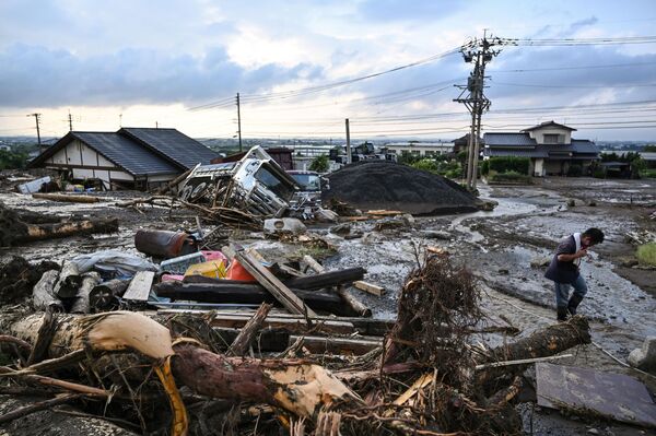 日本福冈久留米市遭遇洪水。图为一名男子在洪水后的废墟中行走。 - 俄罗斯卫星通讯社
