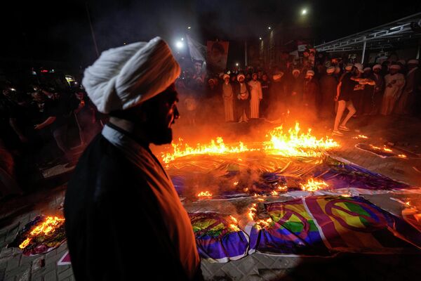 什叶派穆斯林领袖穆克塔达·萨德尔的支持者在伊拉克巴格达萨德尔商务中心的示威活动中焚烧彩虹旗，以回应瑞典焚烧《古兰经》的事件。 - 俄罗斯卫星通讯社