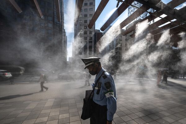 日本东京的一名保安走过水雾降温系统。 - 俄罗斯卫星通讯社