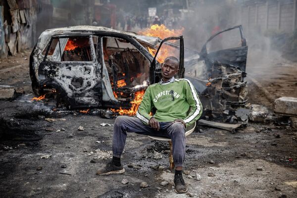 肯尼亞反對派支持者坐在抗議者點燃的汽車前。 - 俄羅斯衛星通訊社