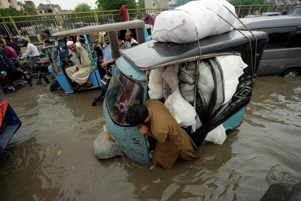 巴基斯坦卡拉奇的一名人力车夫在被暴雨淹没的道路上艰难行进 - 俄罗斯卫星通讯社