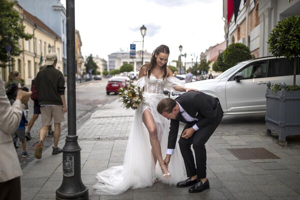 在立陶宛維爾紐斯老城中，一位新郎正在幫助新娘脫鞋 - 俄羅斯衛星通訊社