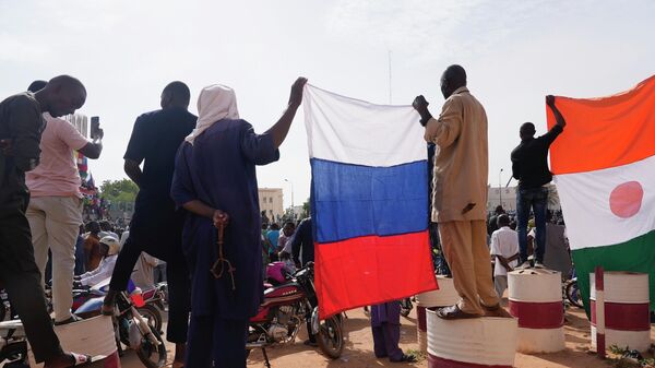 Нигерийцы с российским флагом в руках участвуют в марше, организованном сторонниками лидера государственного переворота генерала Дж. Абдурахман Кьянти в Ниамее - 俄羅斯衛星通訊社