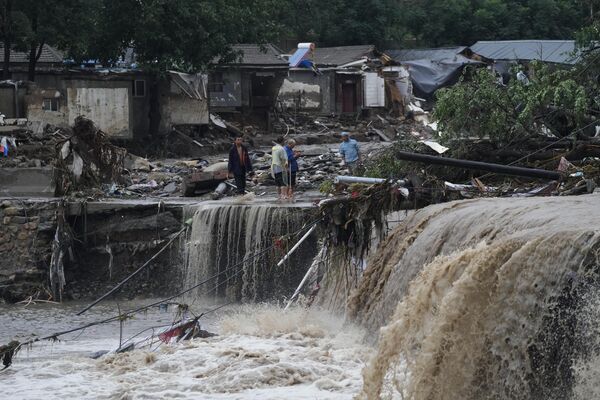 2023年7月31日，北京暴雨，村民們聚集在門頭溝區一個被洪水沖毀的村莊附近。(美聯社/Andy Wong） - 俄羅斯衛星通訊社