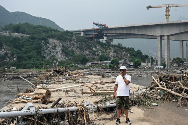 8月3日，北京强降雨过后，一名男子站在洪水手灾区的断桥下。 - 俄罗斯卫星通讯社