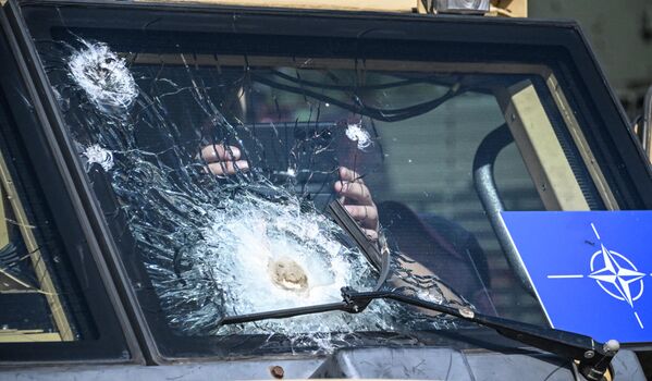 俄罗斯“军队-2023”国际军事技术论坛期间，一名男子透过英国哈士奇装甲车上的破裂挡风玻璃拍照。 - 俄罗斯卫星通讯社