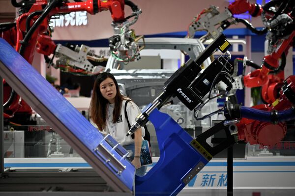 2023年8月16日，在北京举行的2023世界机器人大会上，一名女性参观者在观看机器人手臂。 - 俄罗斯卫星通讯社