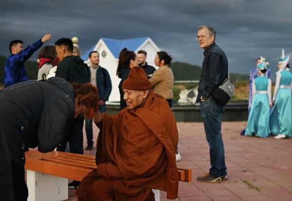 在俄布里亞特共和國貝加爾湖沿岸區的圖爾卡村，一名女子正在與一名僧侶交談。 - 俄羅斯衛星通訊社