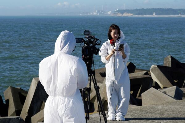 2023年8 月 24 日，星期四，日本浪江町Ukedo渔港附近，身穿防护服的外国媒体工作人员准备拍摄在2011年3月11日的大地震和海啸中受损的福岛第一核电站。日本政府计划在这一天开始将受损的福岛第一核电站处理后的核污水排海。 - 俄罗斯卫星通讯社