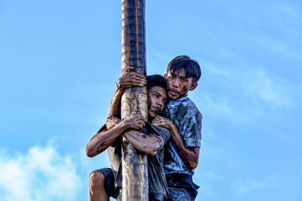 在印度尼西亚举行的为期三天的第78届独立日庆祝活动中，参与者爬上一根名为“Panjat Penang”的、油迹斑斑的杆子，收集悬挂在顶部的奖品。 - 俄罗斯卫星通讯社