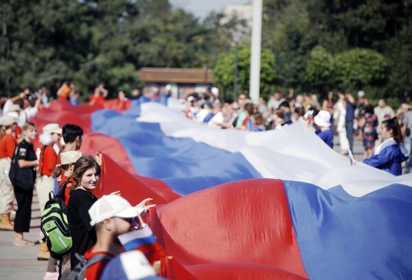 马里乌波尔节日活动的参与者展开一面100米长的俄罗斯国旗。 - 俄罗斯卫星通讯社