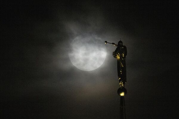 美國馬里蘭州肯辛頓，超級月亮從厚厚的雲層後升起，靠近教堂頂上的天使莫羅尼雕像。 - 俄羅斯衛星通訊社