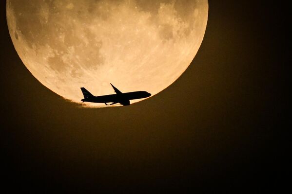 8月30日，一架英國航空公司的空客A320從貝爾法斯特起飛，準備降落在希思羅機場，飛過倫敦天空升起的滿月。 - 俄羅斯衛星通訊社