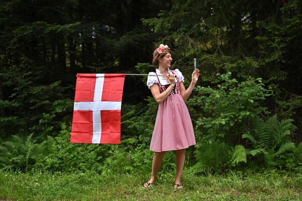 2023年7月15日，第110届环法自行车赛第14赛段，身着丹麦民族服饰的女孩手持国旗。 - 俄罗斯卫星通讯社