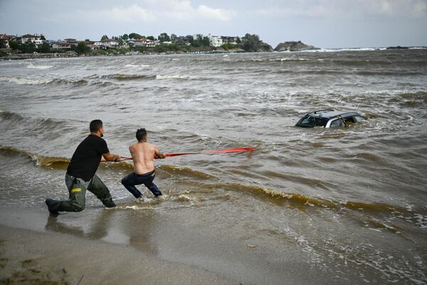 保加利亚，两人正试图拉出因洪水而被冲入大海的汽车。 - 俄罗斯卫星通讯社