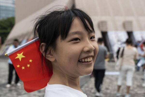 中国国庆节，头发上插着中国国旗的女孩。 - 俄罗斯卫星通讯社