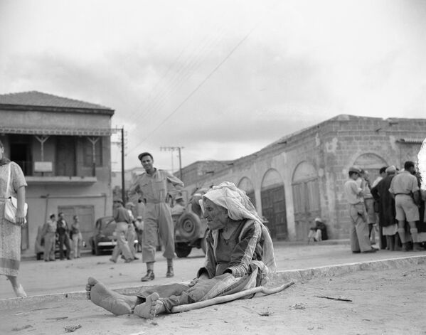 1948年11月13日，一位阿拉伯老婦人坐在內蓋夫沿海小鎮埃爾邁季達爾工業大街的塵土中。 - 俄羅斯衛星通訊社